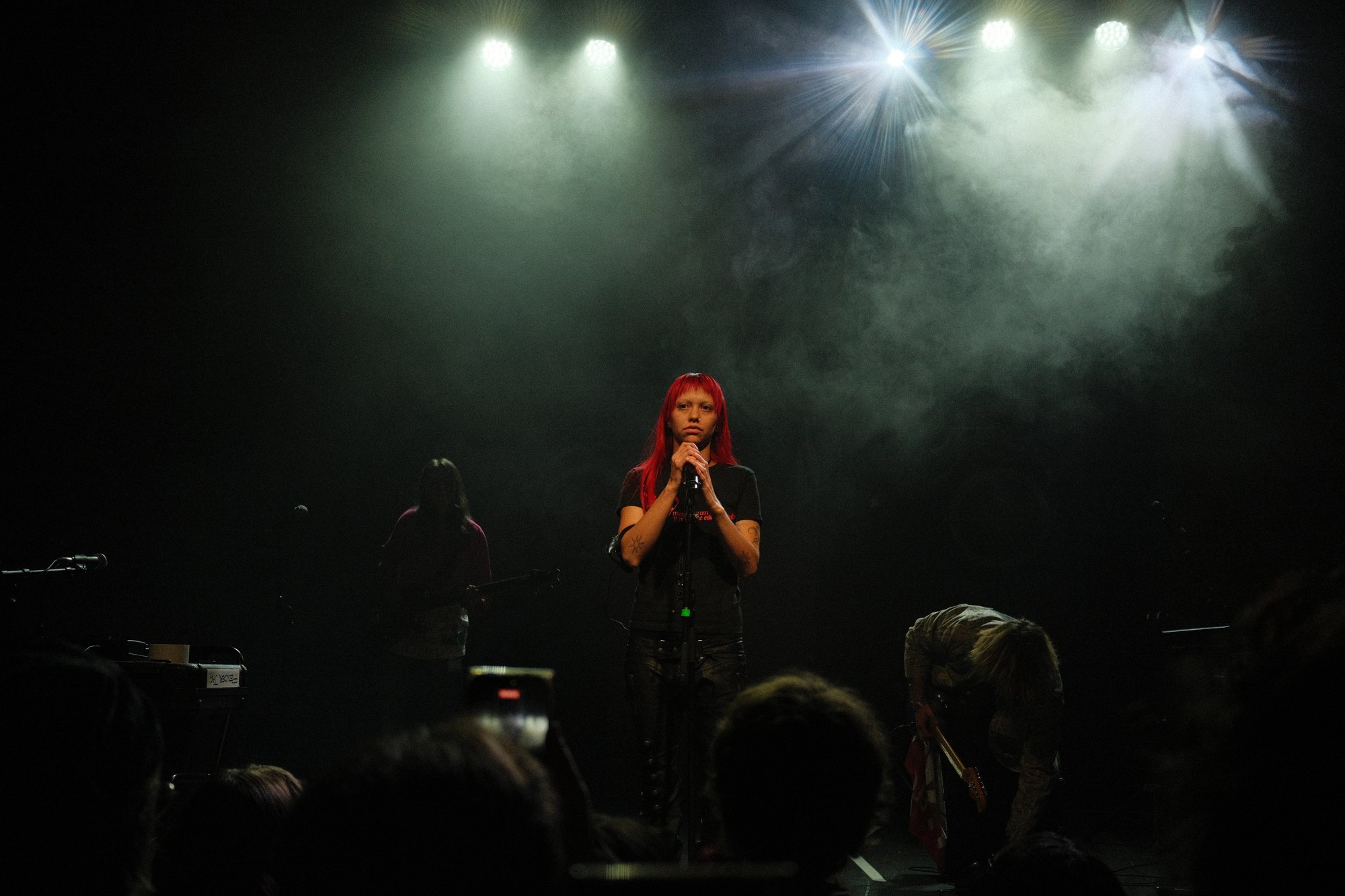 akriila at the mic in green-white stage haze