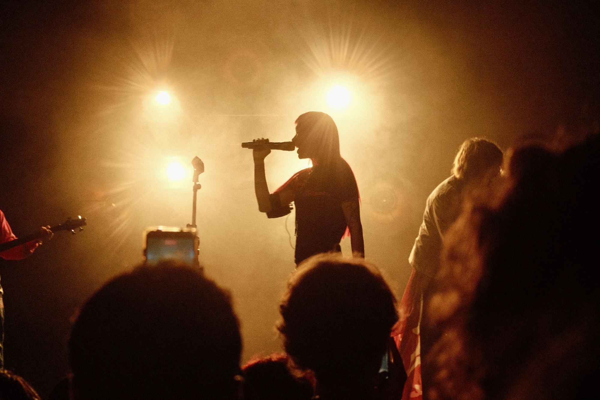 akriila singing in silhouette against warm backlight