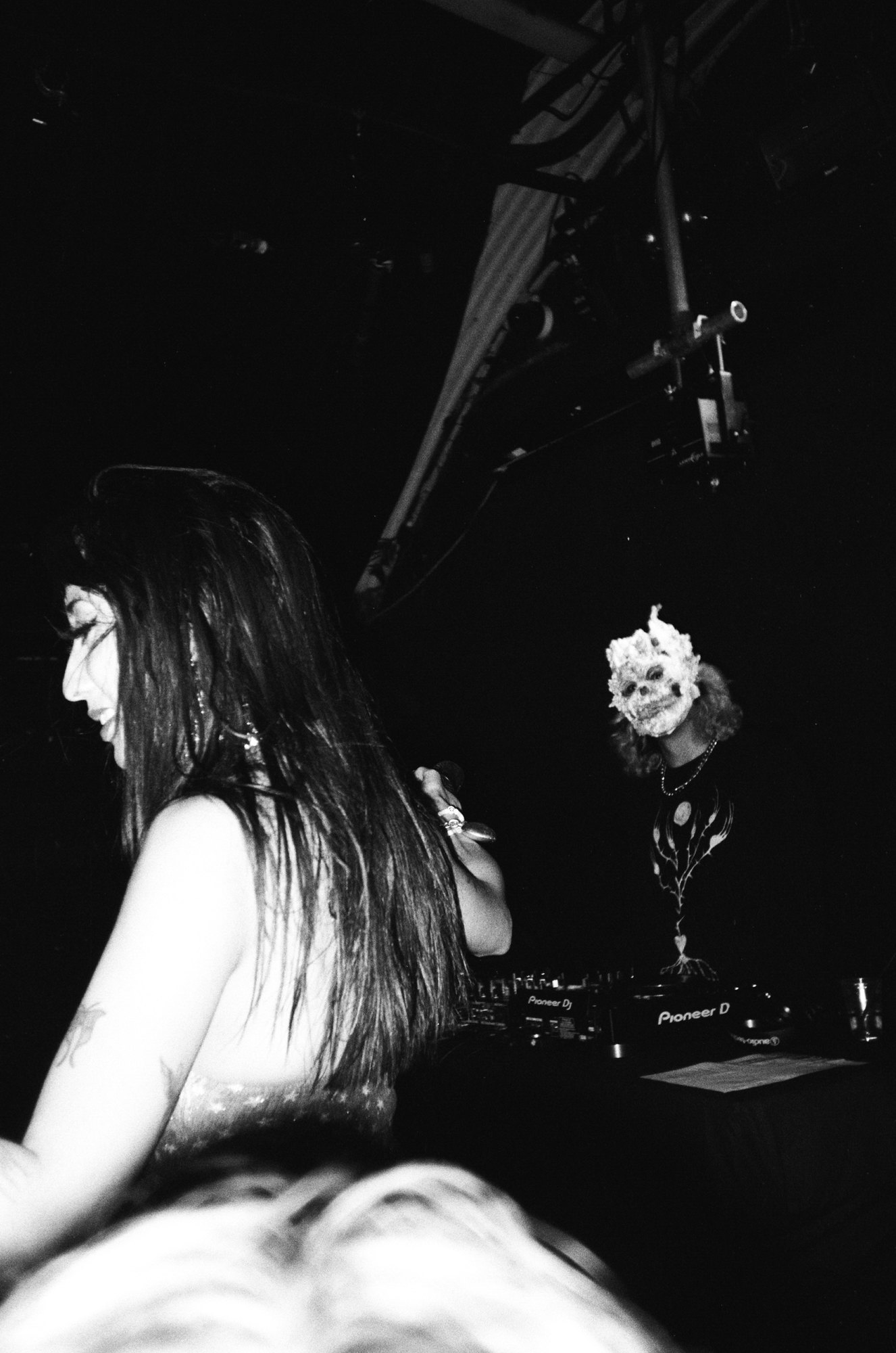 Isabella Lovestory on stage with a masked DJ behind her