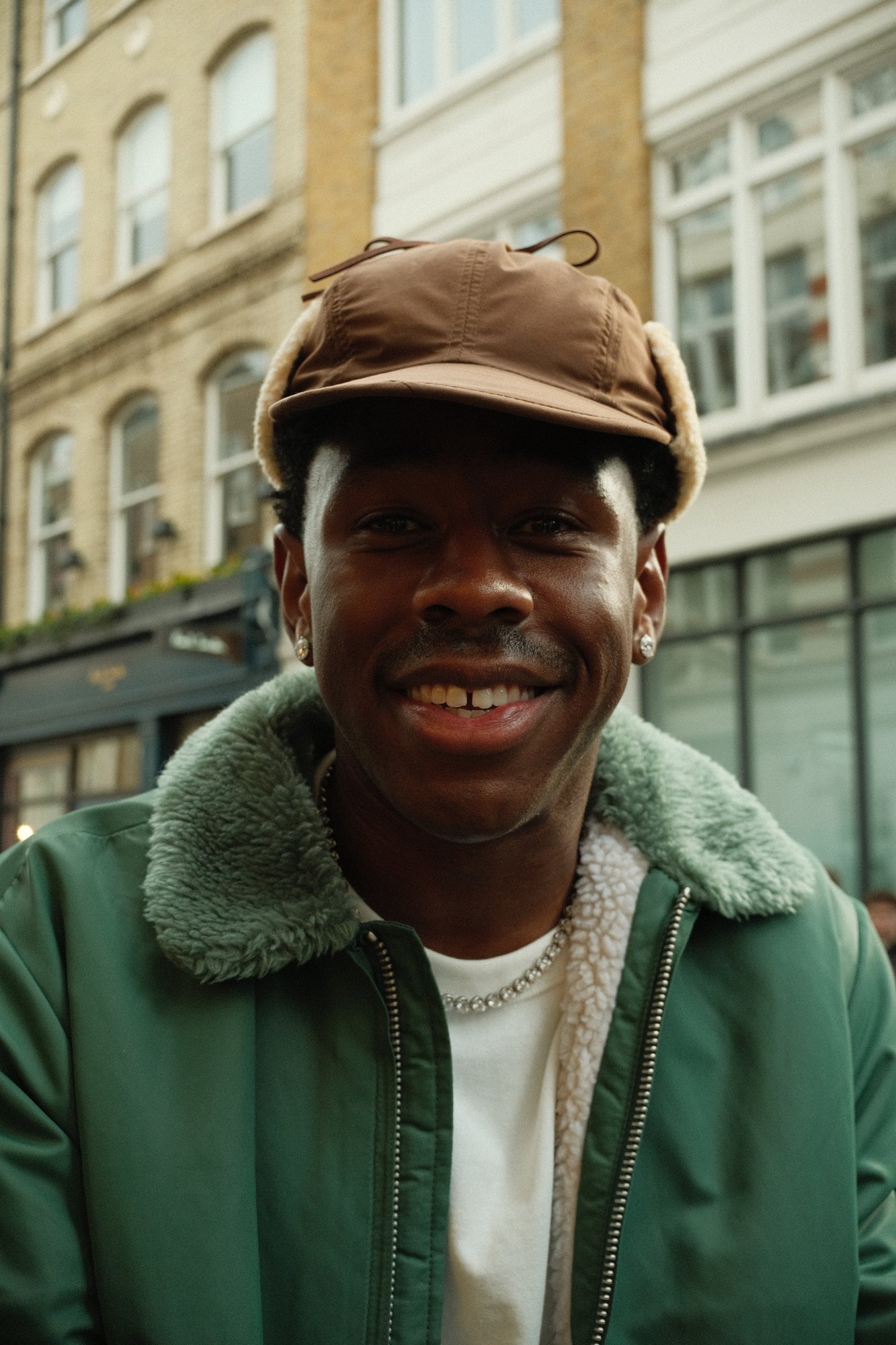 Street portrait of Tyler, the Creator smiling in London